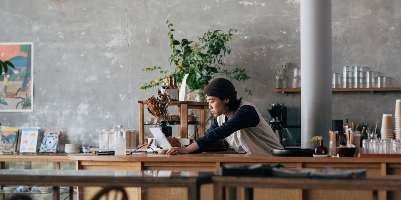カフェの店内。カウンターで作業する店員と、吊り下げの照明
